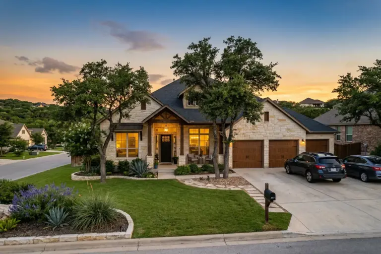 Beautiful family home in the Texas Hill Country at sunset with limestone exterior and live oak trees in Bee Cave Texas