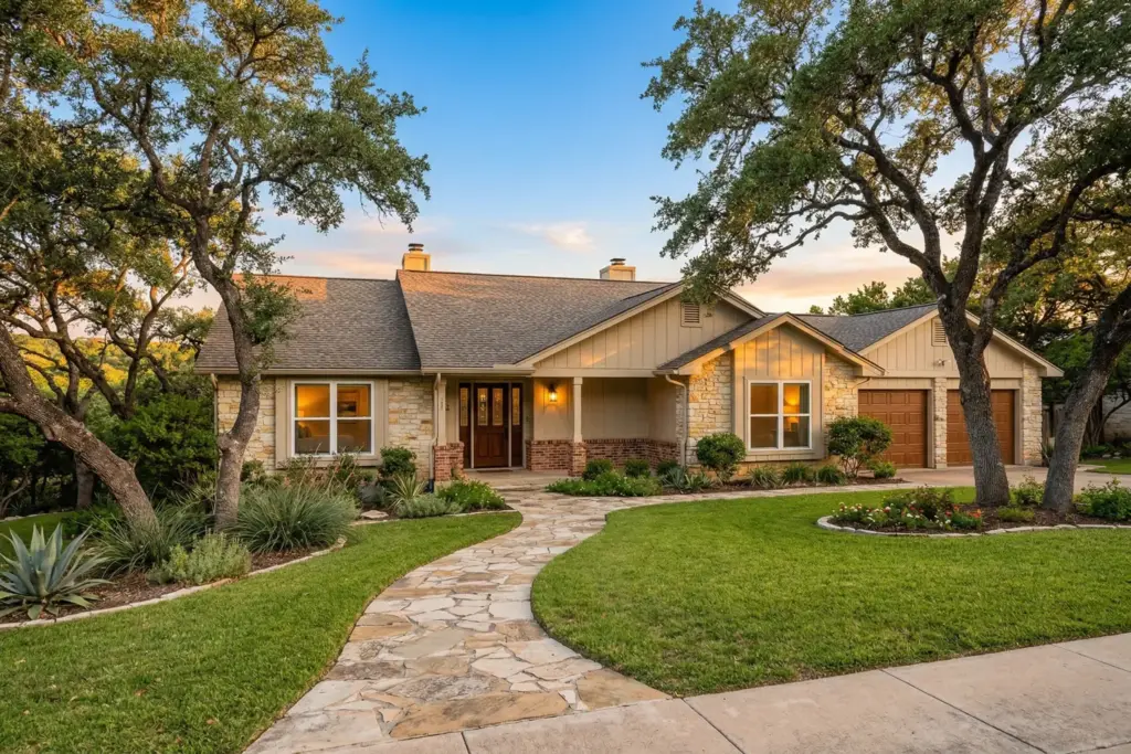 Classic ranch-style Austin home with mature live oak trees and stone pathway at sunset representing an inherited property in the Texas Hill Country