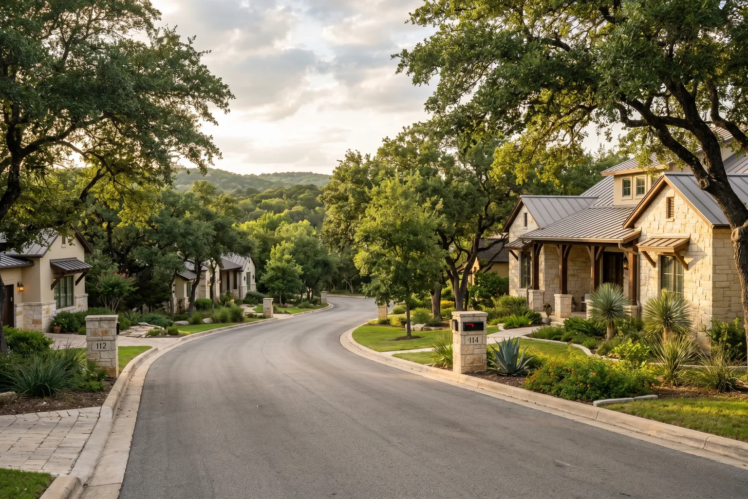 Residential street with limestone homes and live oak trees in the Texas Hill Country west of Austin