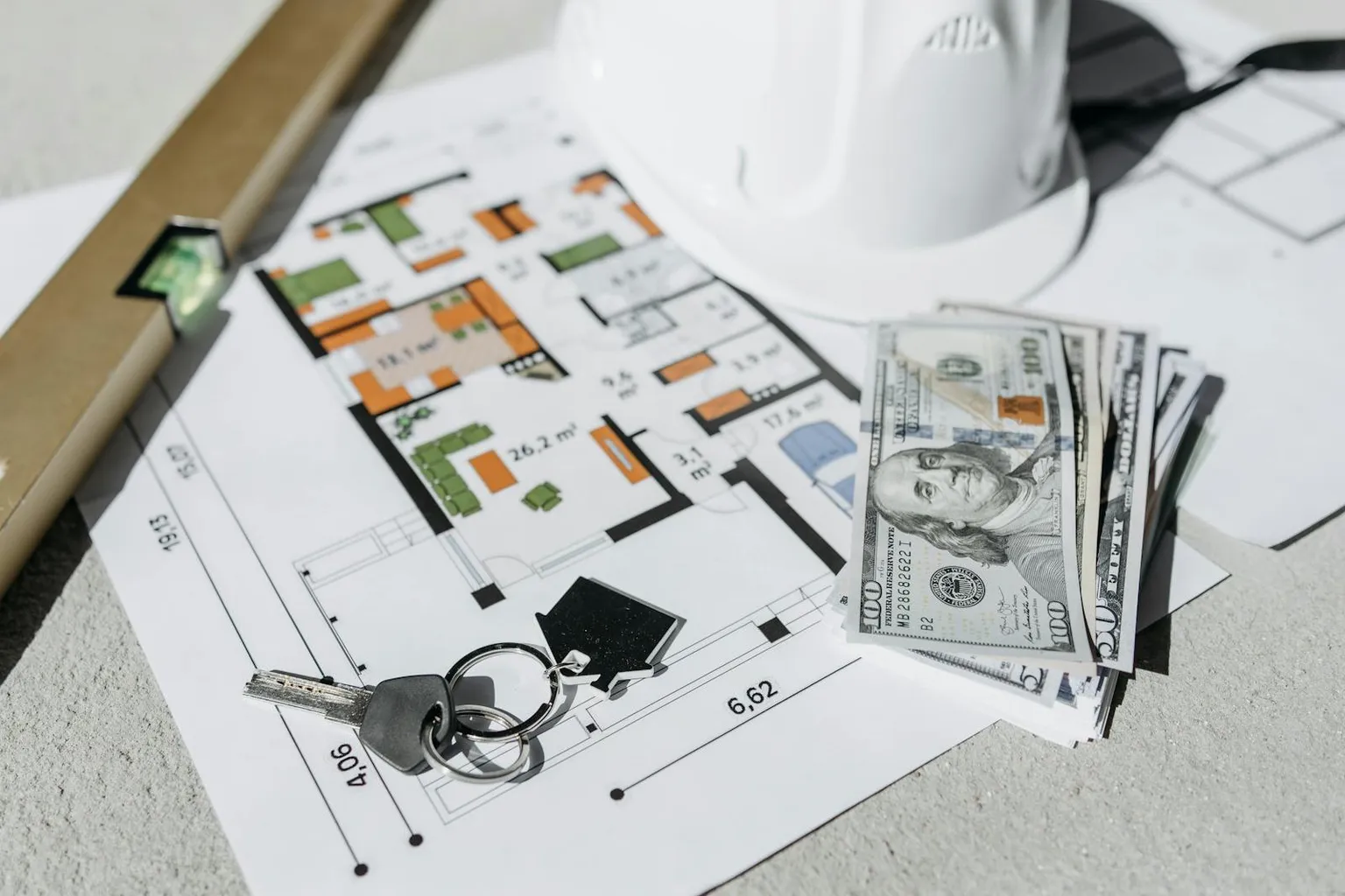 Cash, house keys, and floor plans representing the financial aspects of closing on a Texas home
