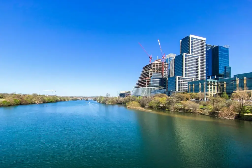 Austin Texas downtown skyline reflecting in Lady Bird Lake with green spaces