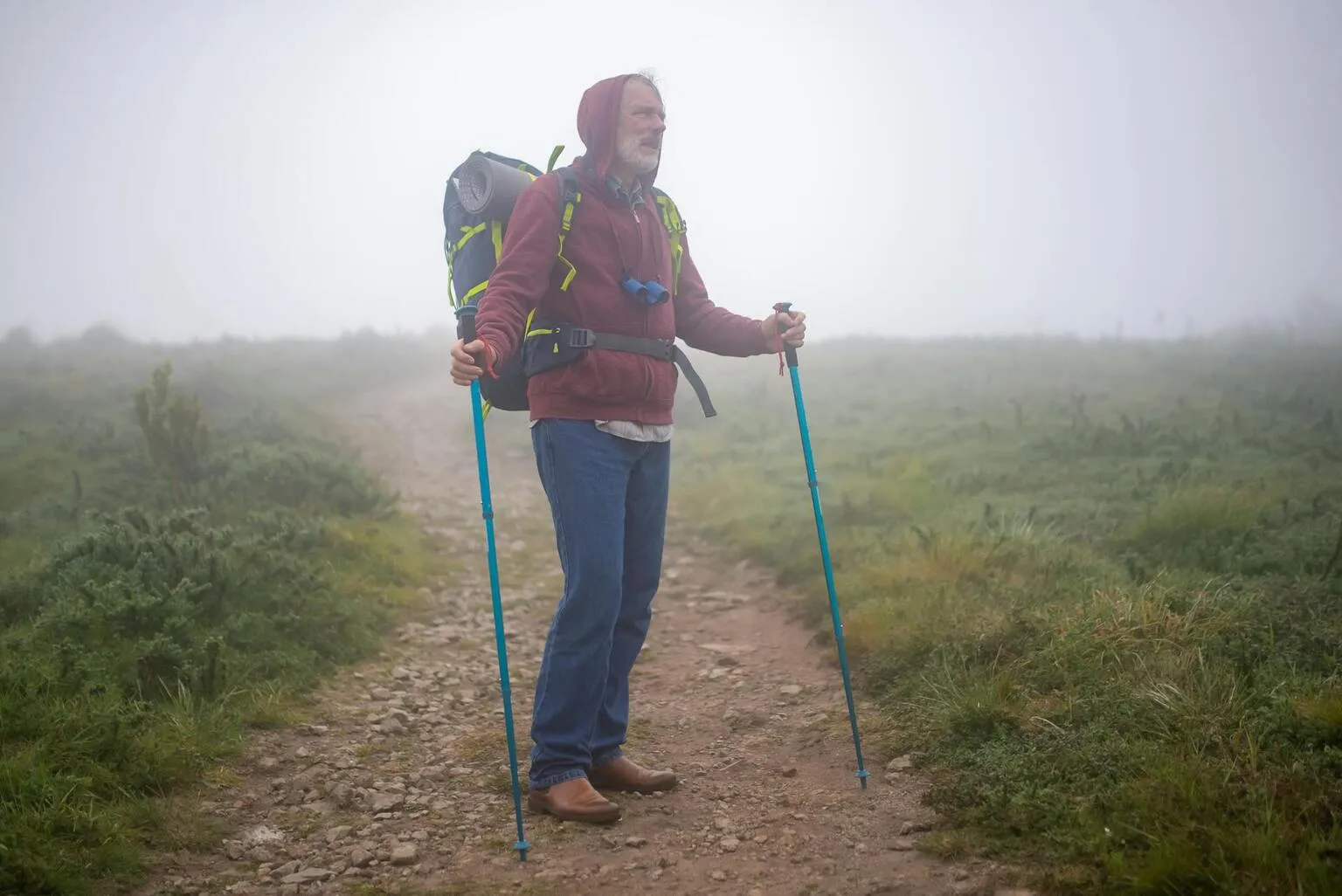 Active senior hiking on a scenic nature trail through the forest