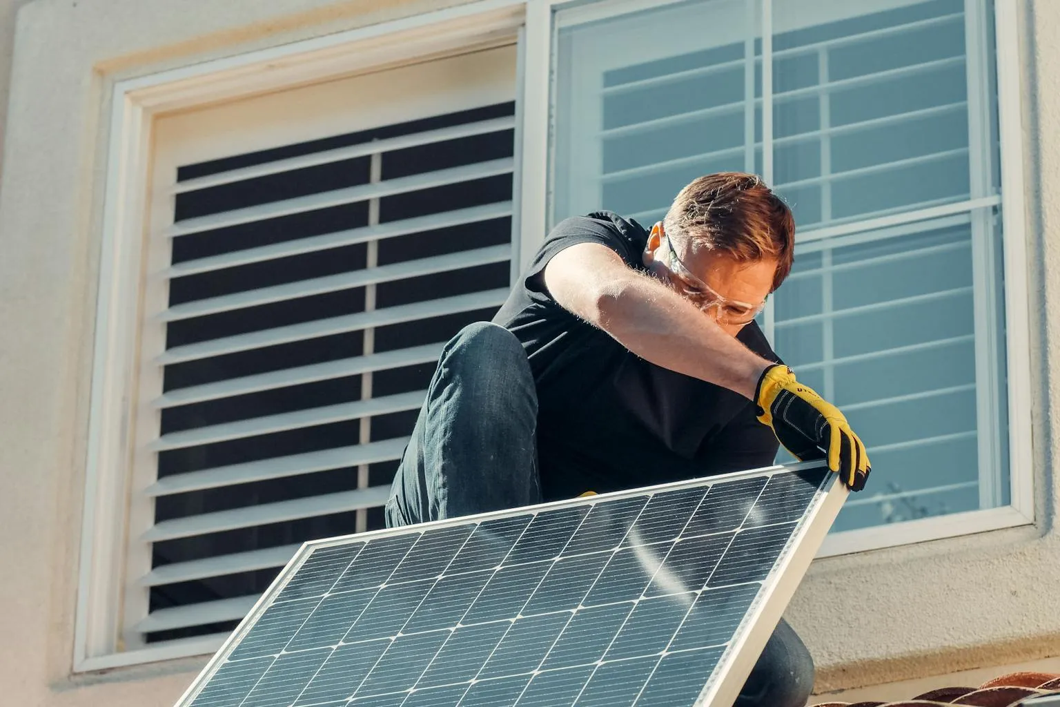 Technician installing solar panels on a residential roof