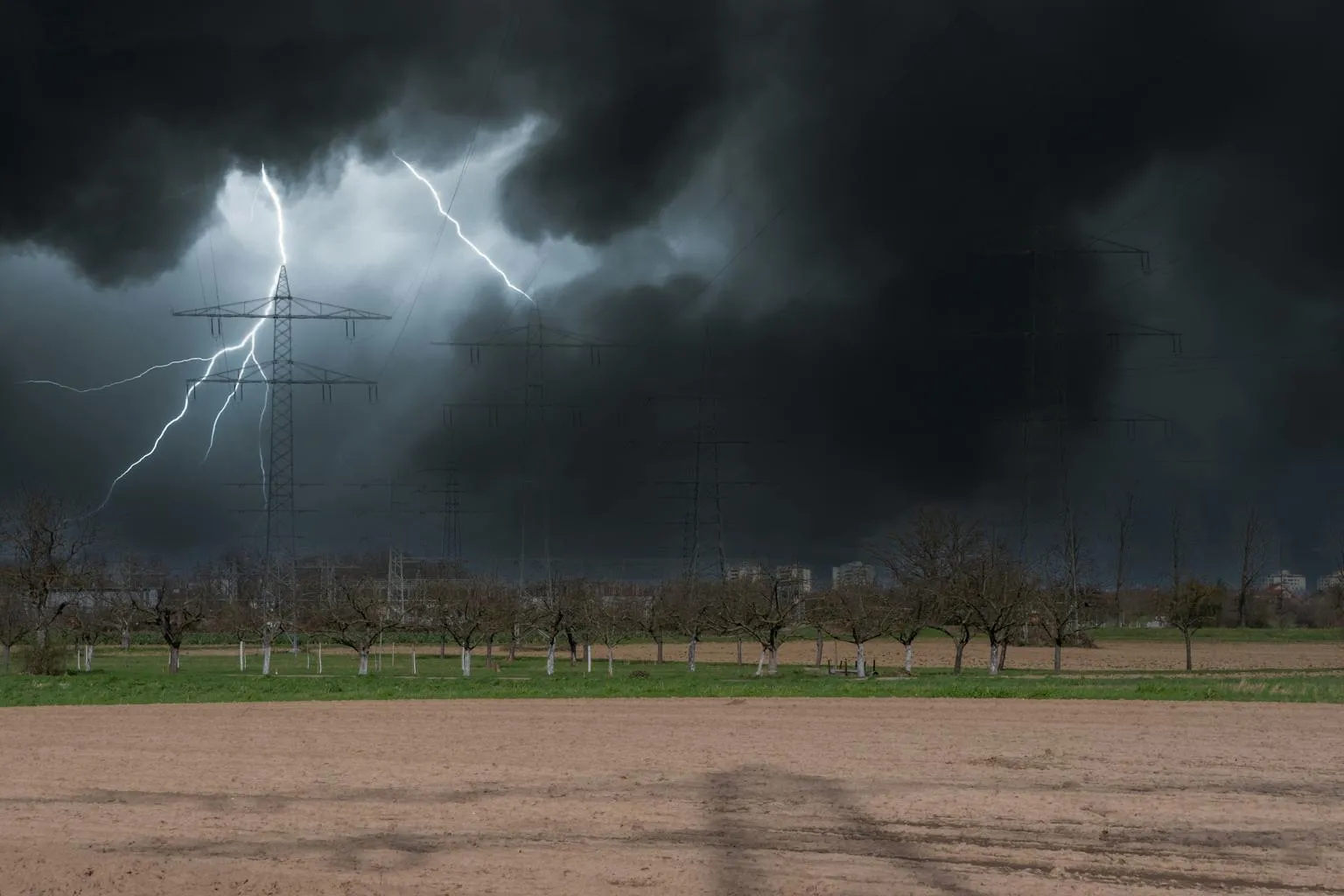 Lightning bolt illuminating dark storm clouds over rural Central Texas landscape