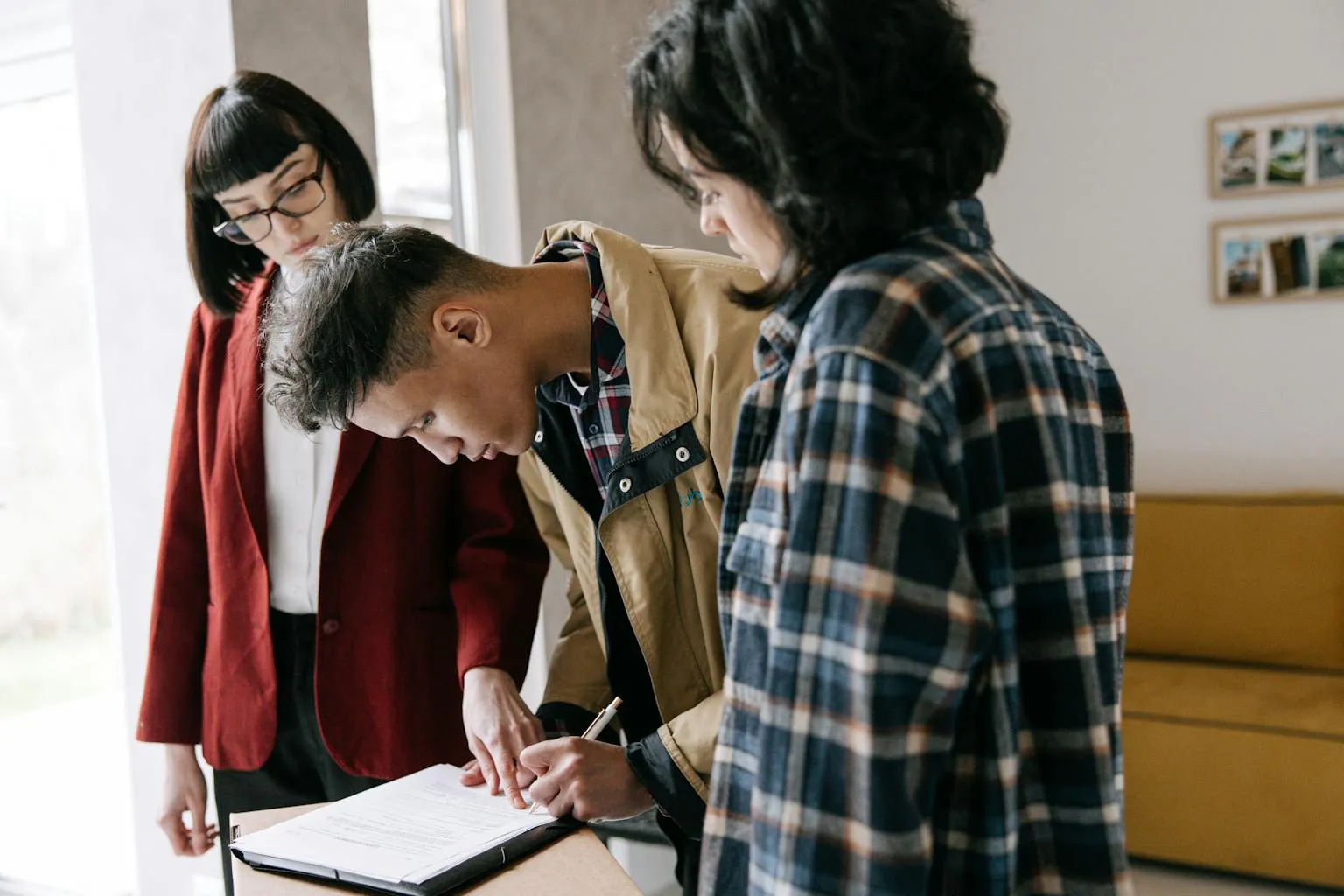 Homebuyers signing mortgage loan documents with lender representative
