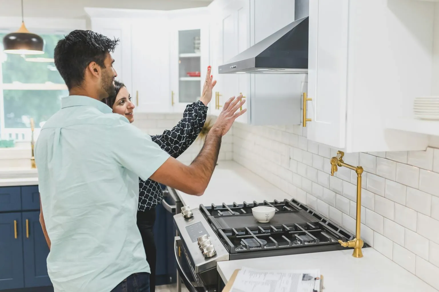 Real estate agent giving a home tour and showing kitchen features to prospective buyers