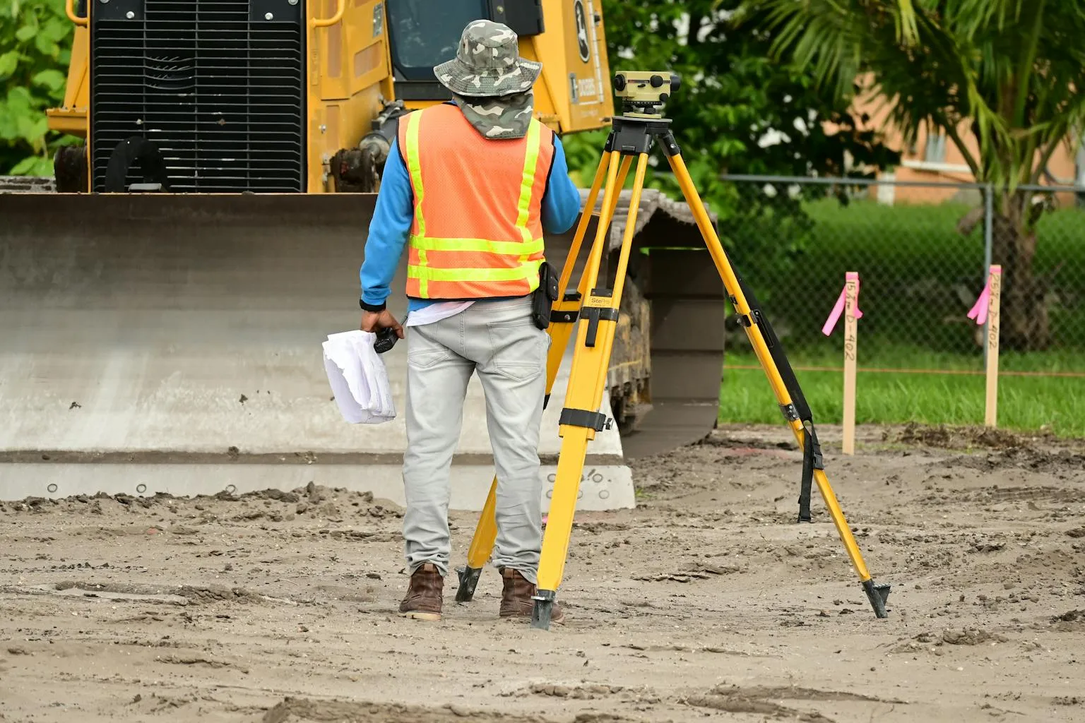 Land surveyor operating total station equipment on a site to measure property boundaries