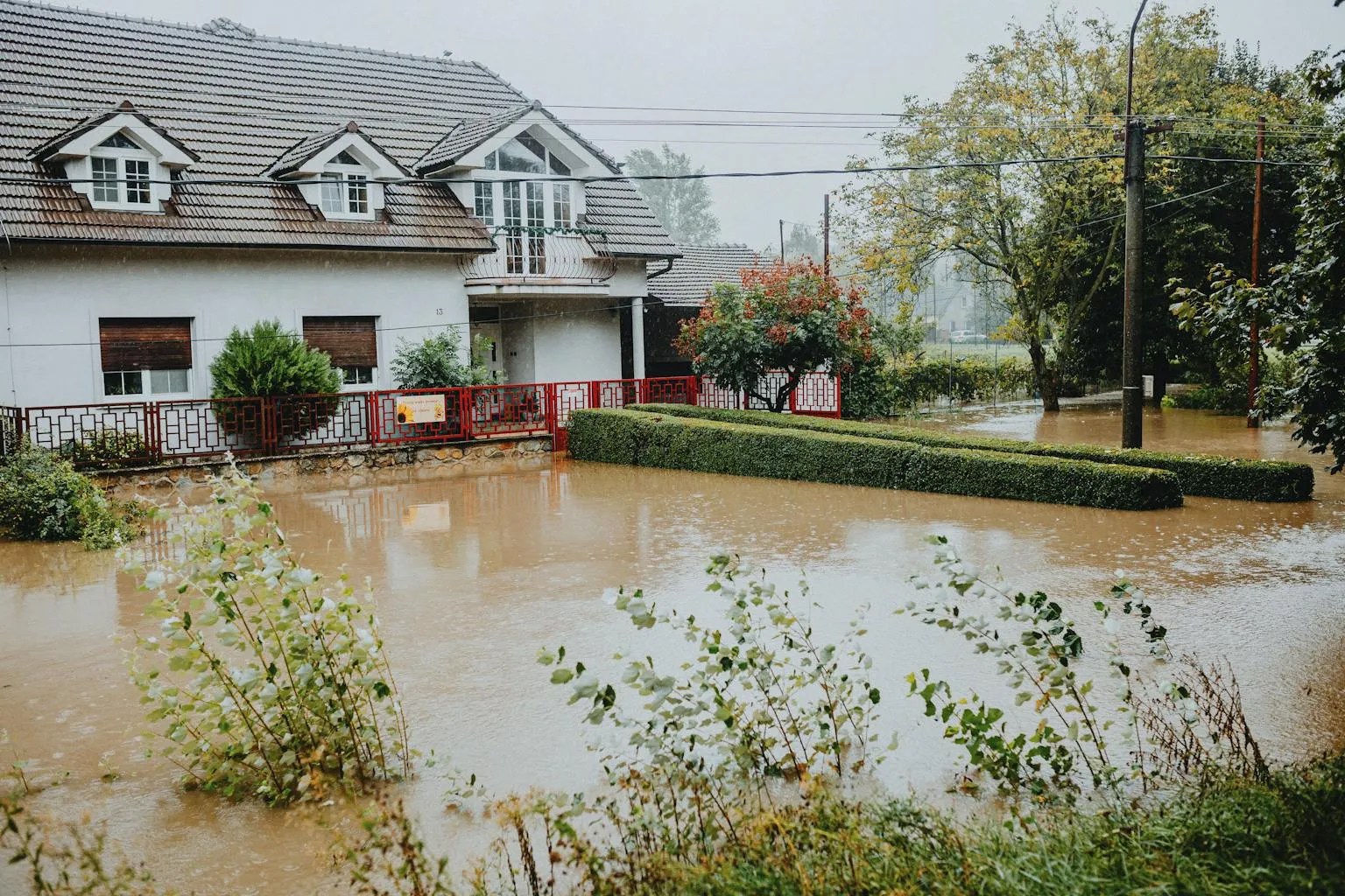 Residential home surrounded by floodwaters showing flood damage risk