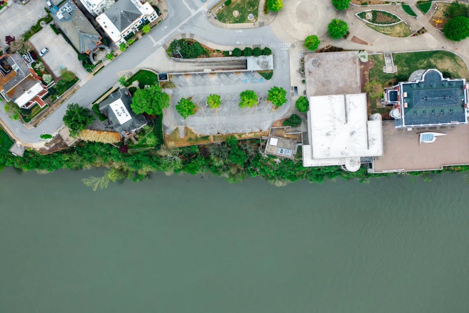 Overhead view of buildings situated directly adjacent to a river showing flood zone proximity