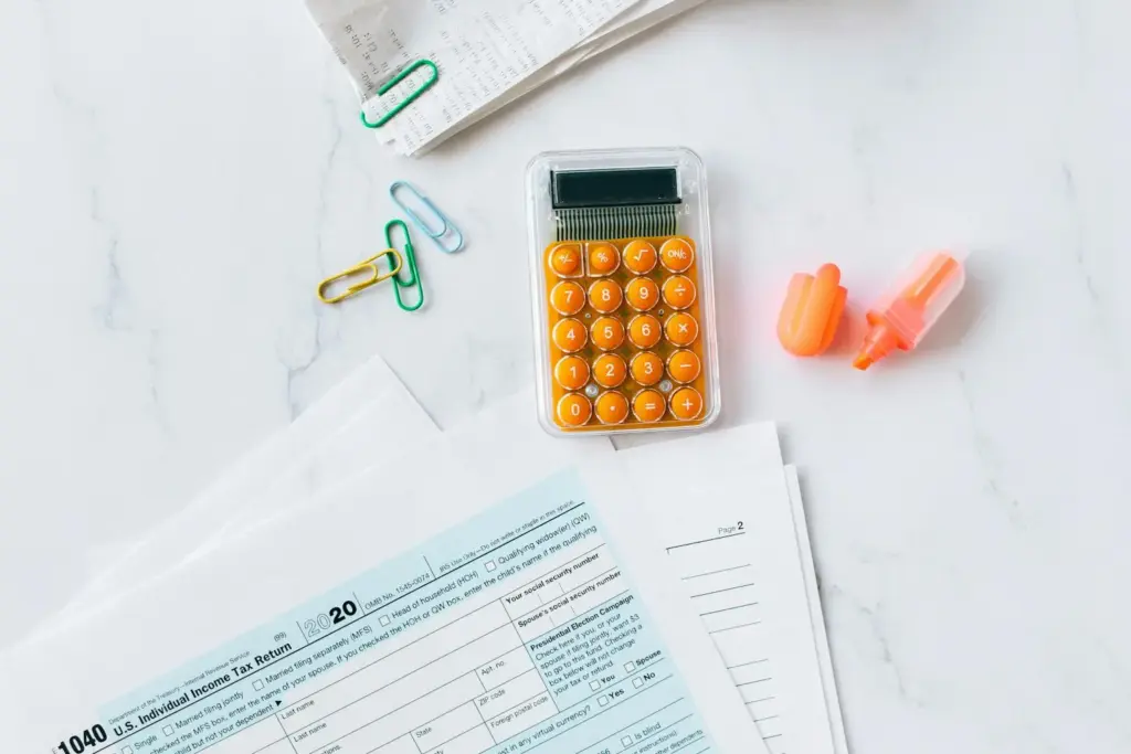 Tax forms and financial documents with calculator on a wooden desk