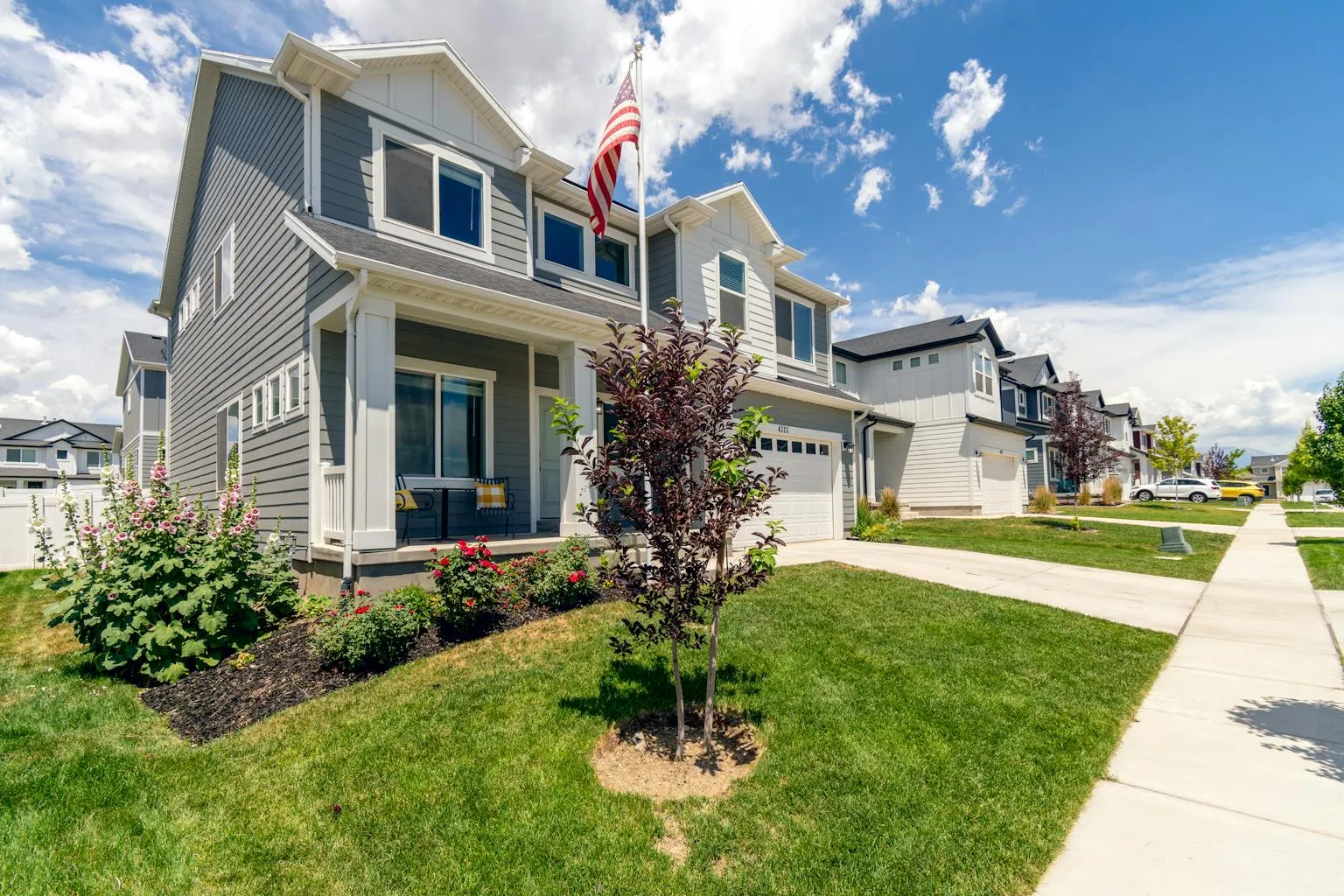Modern suburban home with landscaped yard and American flag