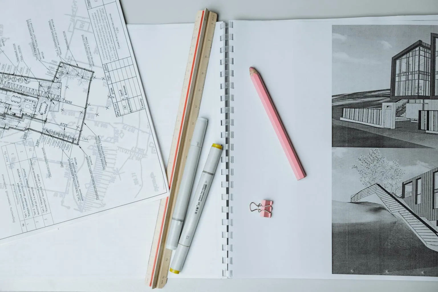 Architectural blueprints and floor plans spread on a desk showing building design details