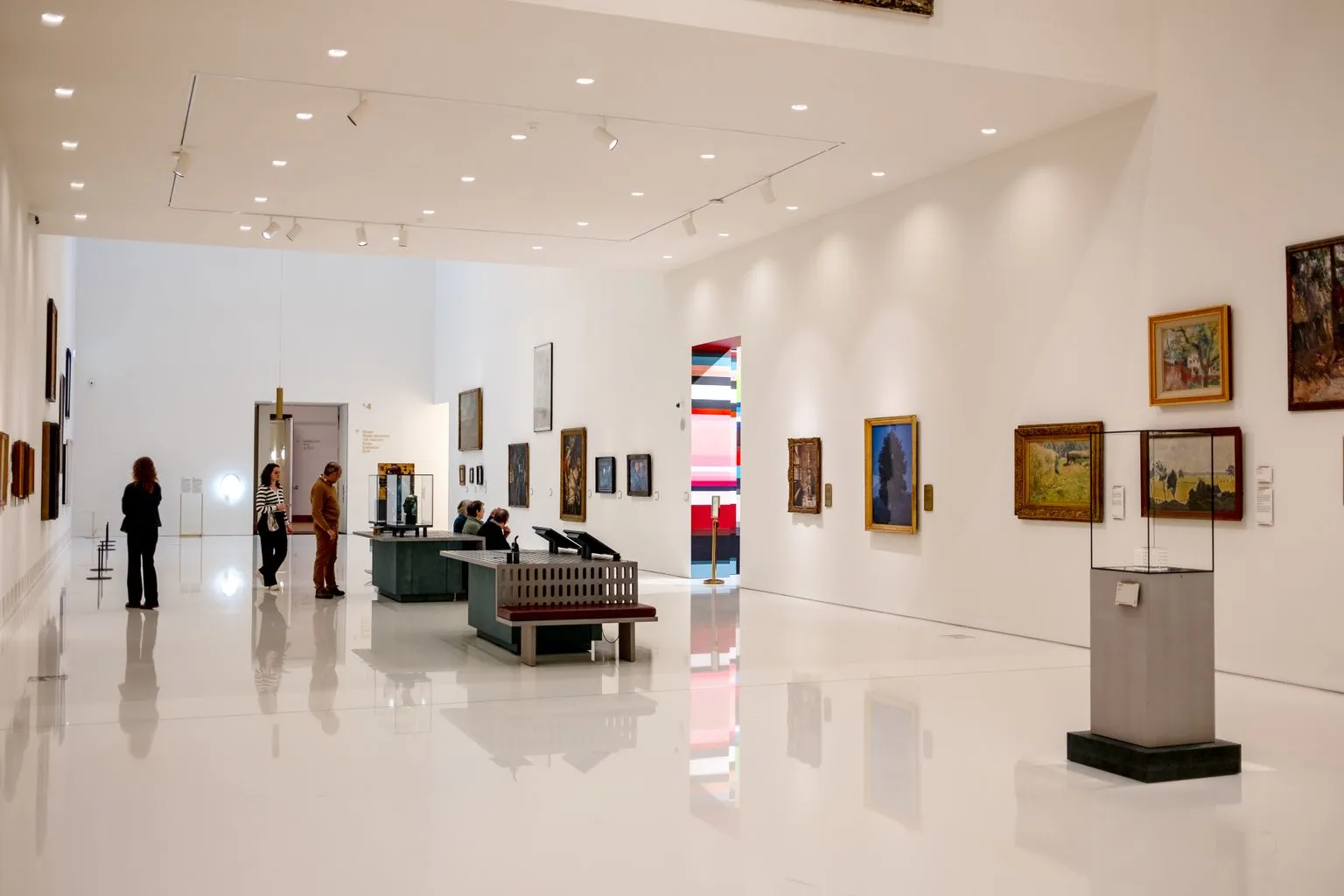 Visitors browsing contemporary art exhibitions inside a modern museum gallery
