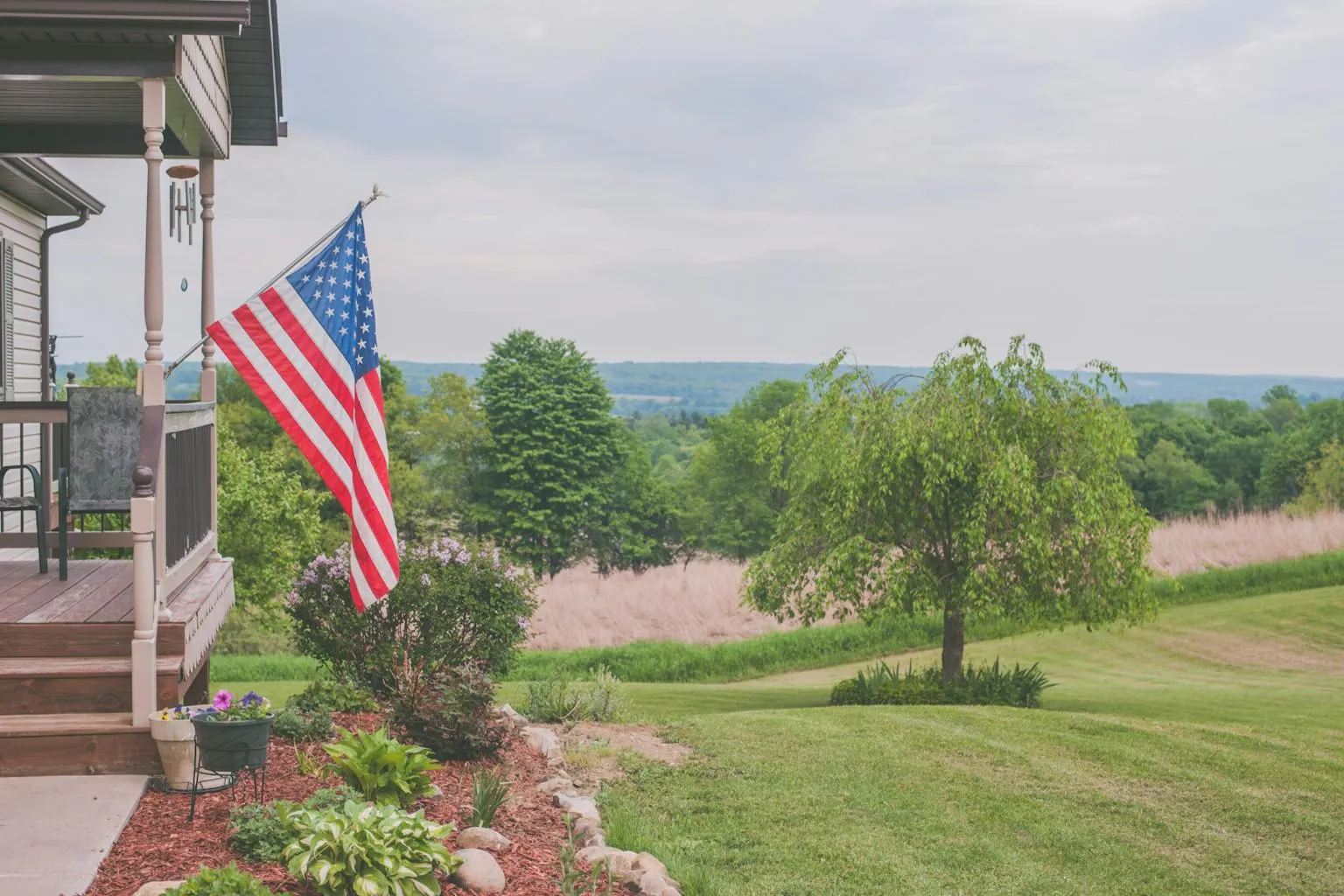 Residential home with American flag on a tree-lined street