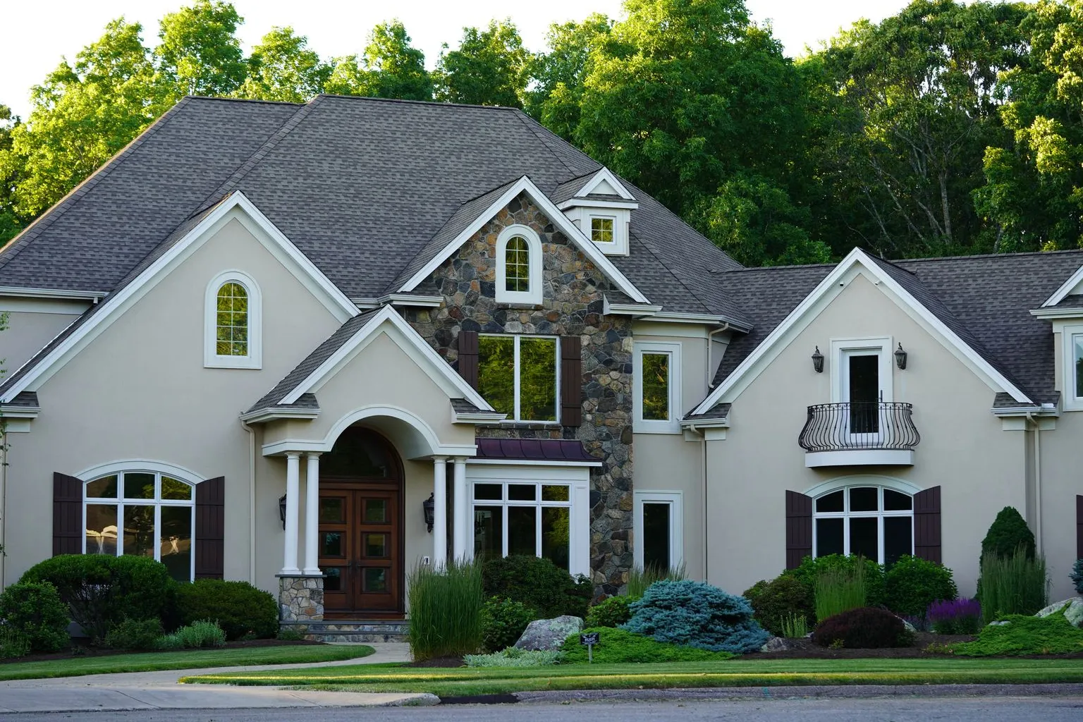 Large suburban home surrounded by mature trees and well-maintained landscaping