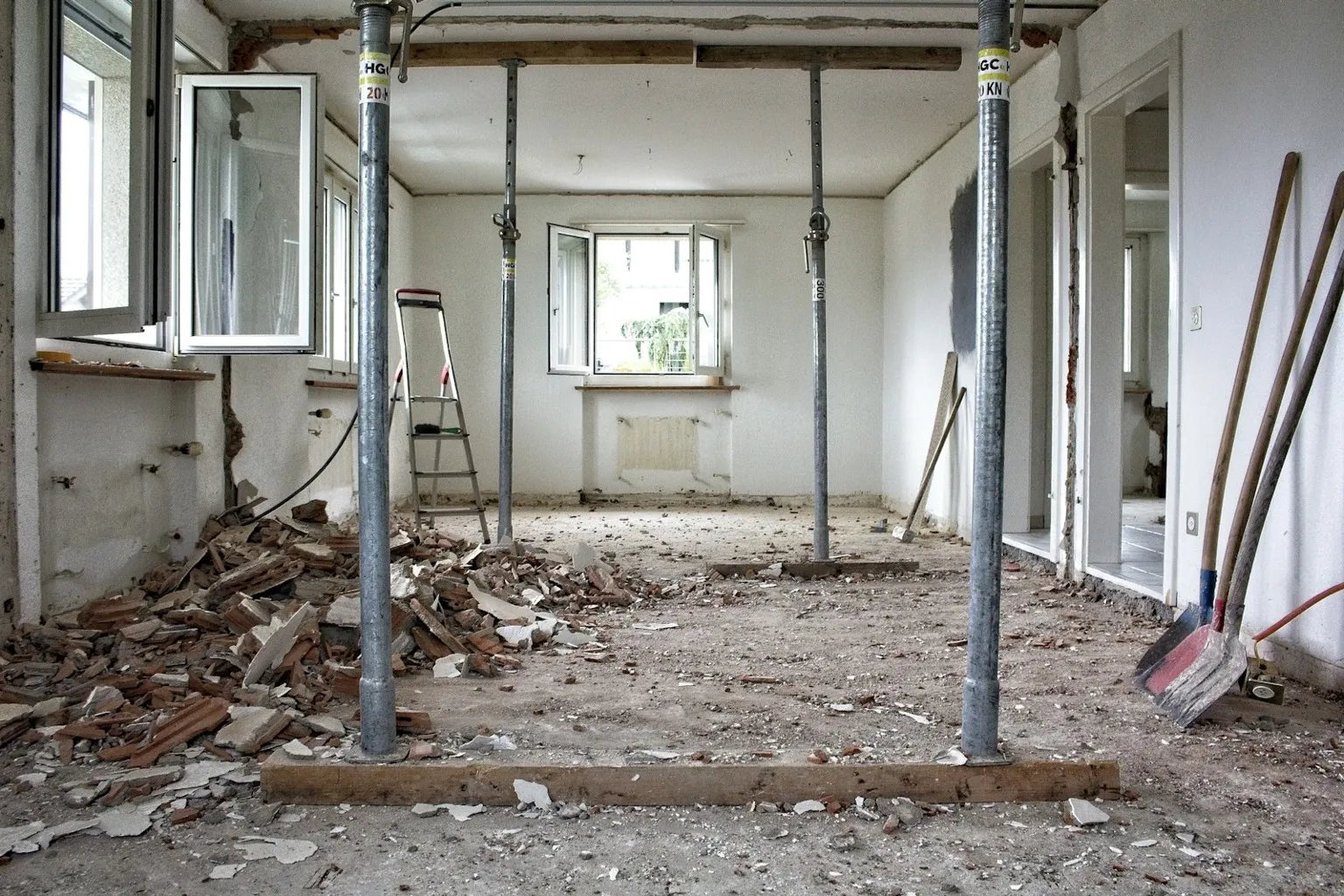 Interior of a home under renovation with structural supports and debris